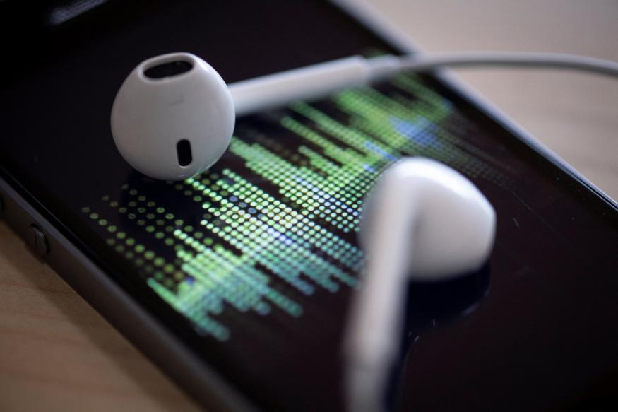 A picture taken on February 8, 2019 in Paris shows a smartphone and its earphones as an audio podcast is being played. (Photo by Thomas SAMSON / AFP) (Photo by THOMAS SAMSON/AFP via Getty Images)