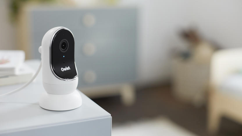 Owlet baby monitor camera sitting on the edge of a desk in a home nursery.