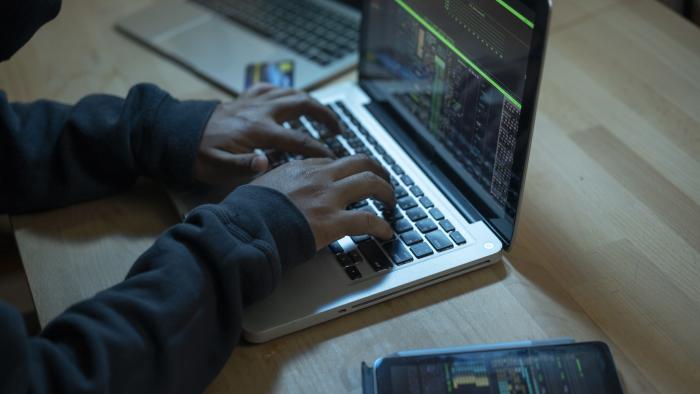 Close up of hands typing on laptop. Night work concept