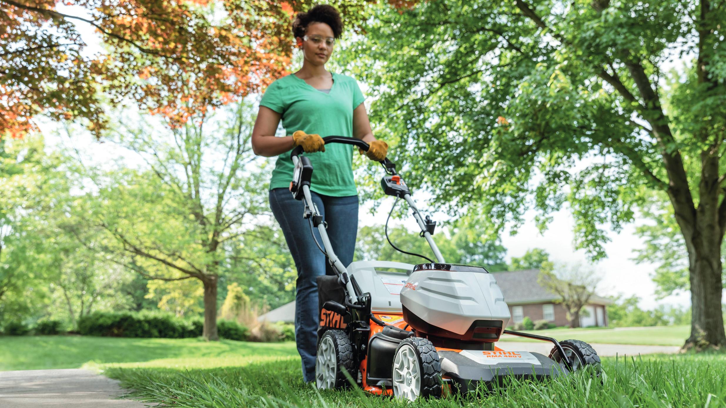 Image of Gas lawn mower with a man standing next to it