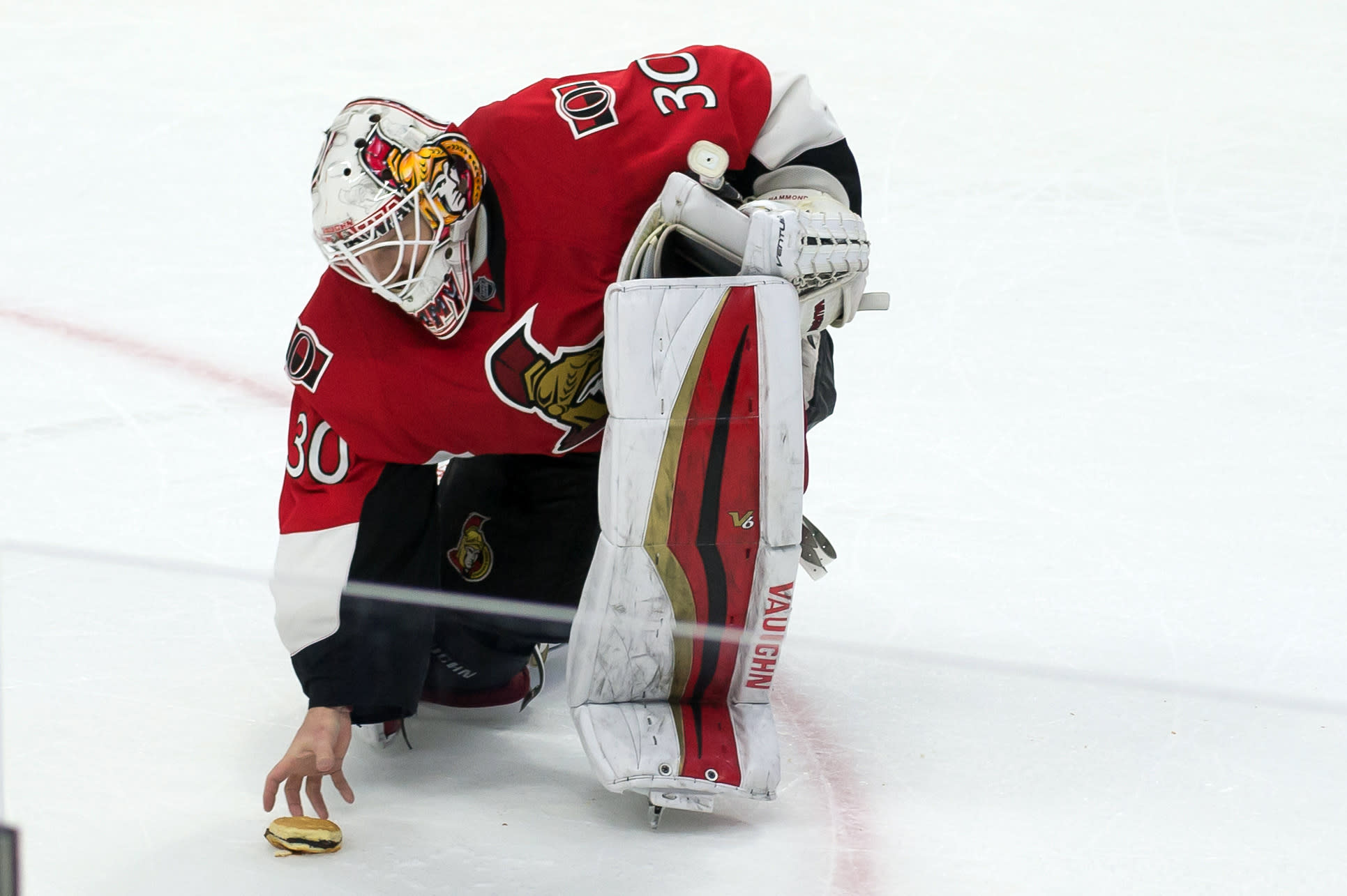 Andrew Hammond picks up a hamburger after a win in Ottawa