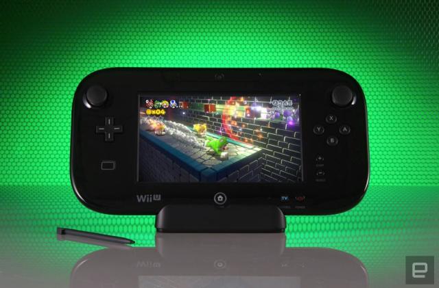The Wii U gamepad propped up in front of a green honeycomb-style background. Its stylus sits next to it, and it has a prominent reflection below.