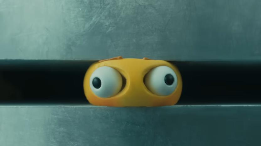 A yellow emoji being crushed in an industrial crusher. Its eyes bulge out of its head.