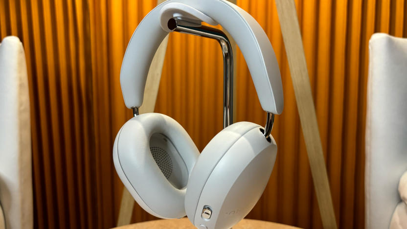 White headphones on stand sitting on a small table. 