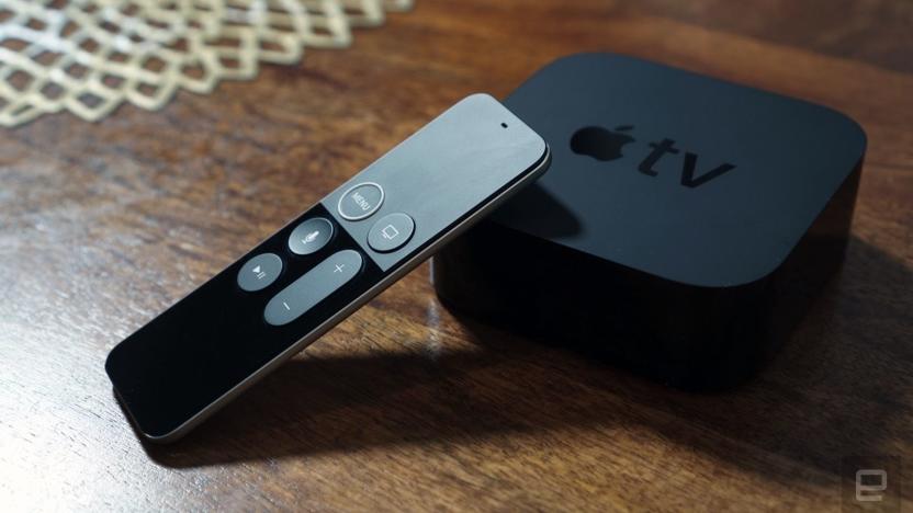 An Apple TV set-top box and remote are displayed on a wooden table top.