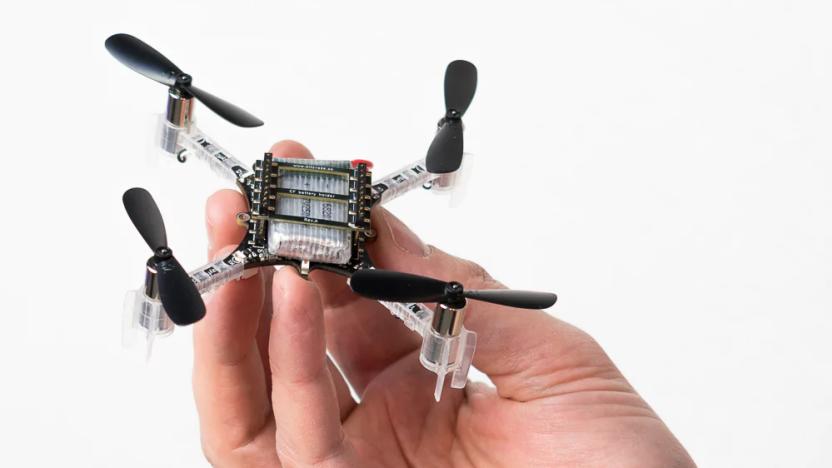 Photo of a hand holding a small quadcopter drone.