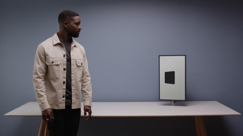 A man looking at a black-and-white display, which shows a black square slightly angled towards the man.