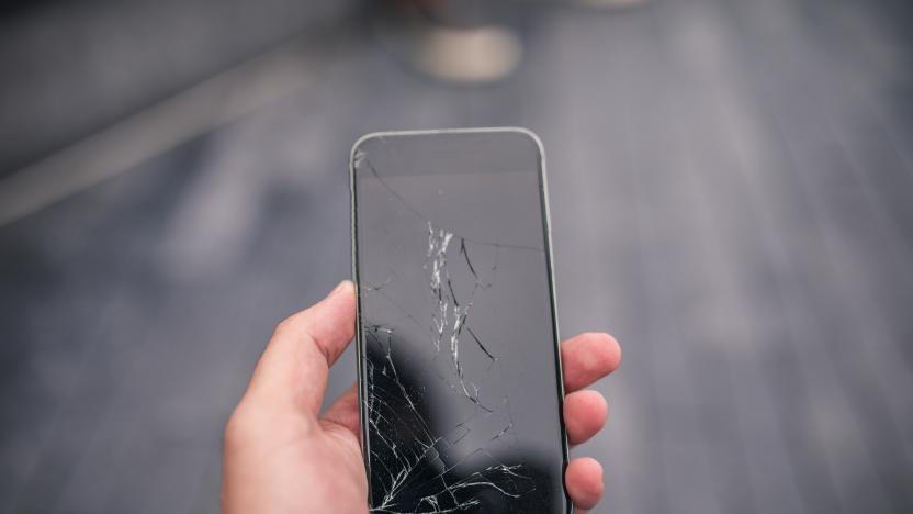 Man holding a broken smart phone in his hand, part of.