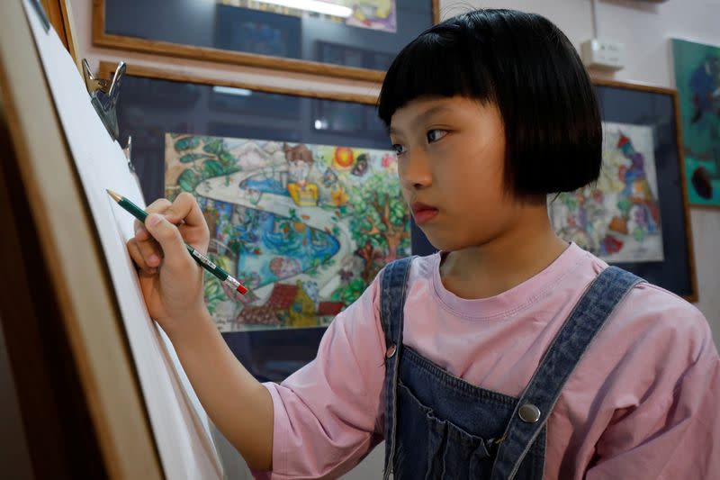 A Vietnamese school girl draws paintings about the coronavirus disease (COVID-19) in Hanoi