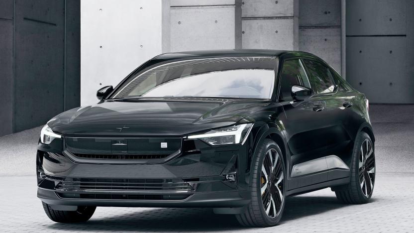 The 2024 Polestar 2 in black is seen parked in a cobbled lot with cement pillars behind hit.