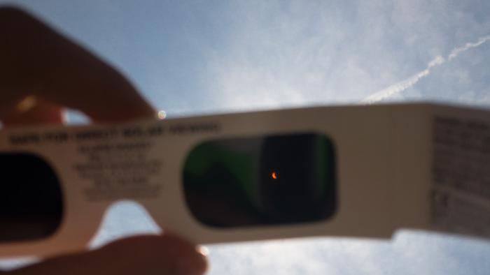 Eclipse being viewed through glasses.