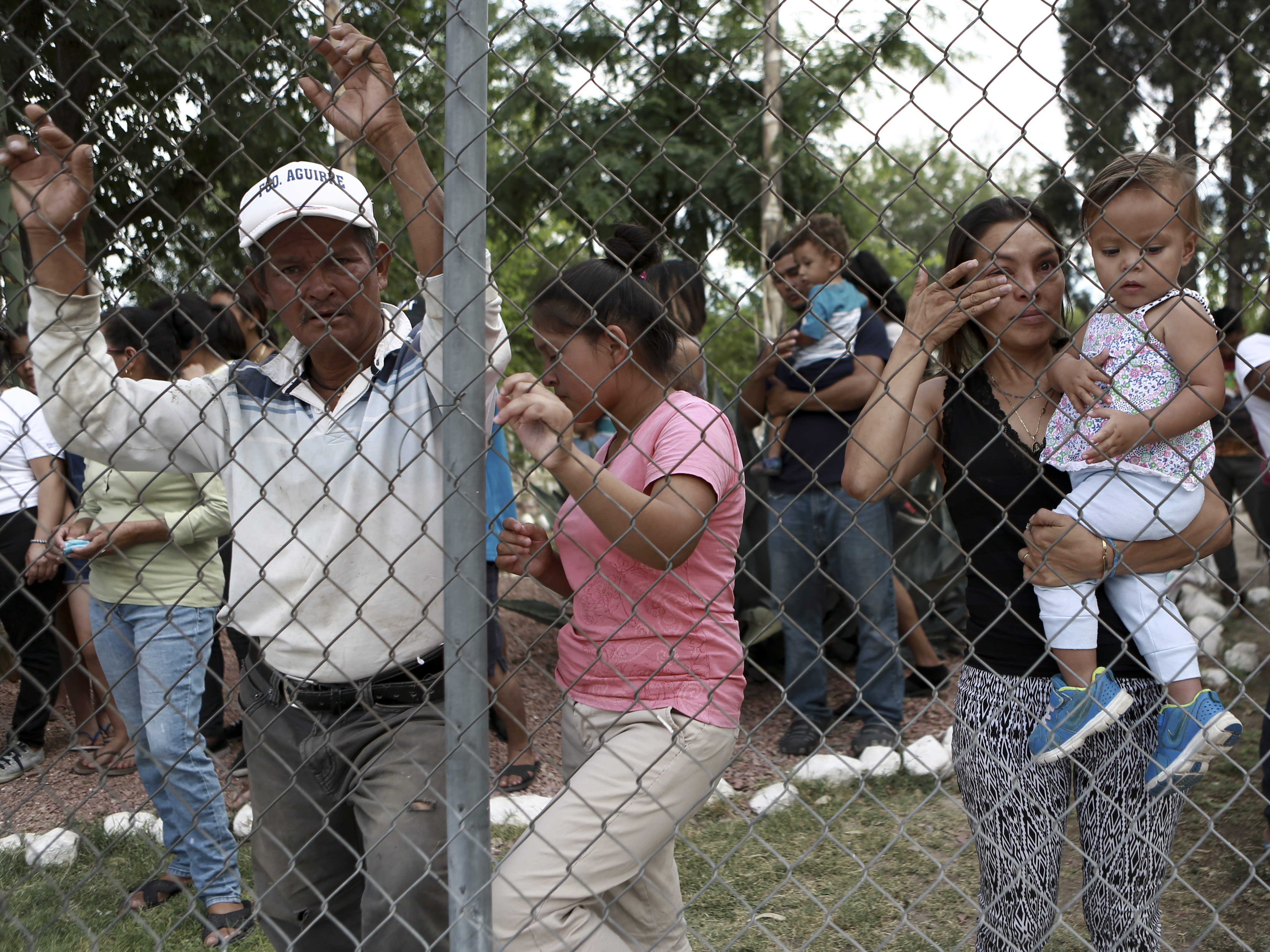 Central American migrants watch fellow migrants board busses as they voluntarily return to their countries, in Ciudad Juarez, Mexico, Tuesday, July 2, 2019. Dozens of Central Americans who had been returned to the border city of Juarez to await the outcome of their U.S. asylum claims are being bused back to their countries Tuesday by Mexican authorities, a first for that size group of people in the program commonly known as âremain in Mexico.â (AP Photo/Christian Chavez)