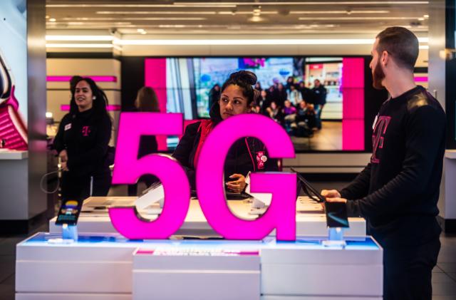 NEW YORK CITY, UNITED STATES - 2020/02/20: Customers at a T-Mobile store, with 5G signage. (Photo Illustration by Alex Tai/SOPA Images/LightRocket via Getty Images)