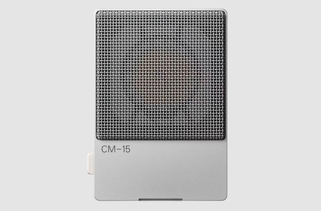 A front view of the Teenage Engineering CM-15 microphone in grey. It's essentially a tall rectangle with a speaker grill on the top three fourths.