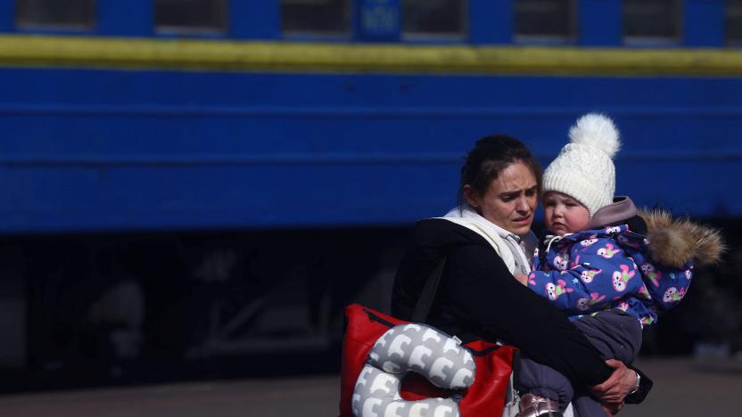 A mother holds her girl after arriving by a train from north eastern Ukraine transporting refugees fleeing the ongoing Russian invasion, at the main train station in Lviv, Ukraine, March 12, 2022.  REUTERS/Kai Pfaffenbach