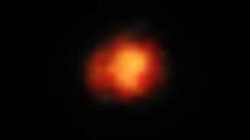 A glowing red blob in black space. It’s an image of Maisie’s galaxy, a system calculated to be from 390 million years after the Big Bang.  