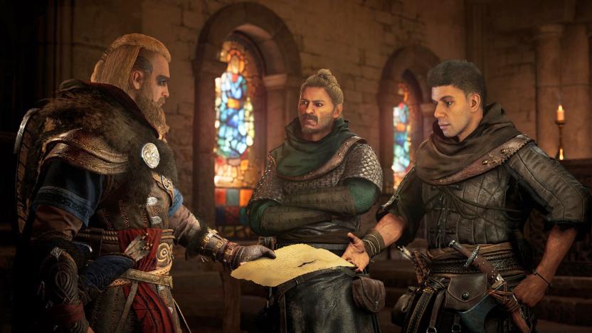 In this promotional still for 'Assassin's Creed Valhalla', one man in armor hands two other men in armor a piece of paper. Stained glass windows are behind them. 