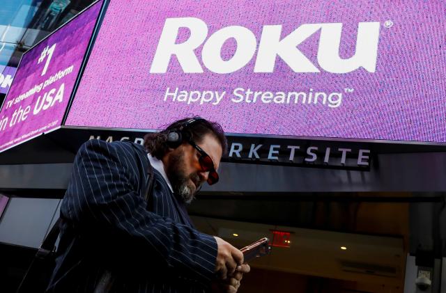 A man passes by a video sign display with the logo for Roku Inc, a Fox-backed video streaming firm, after the company's IPO at the Nasdaq Marketsite in New York, U.S., September 28, 2017. REUTERS/Brendan McDermid