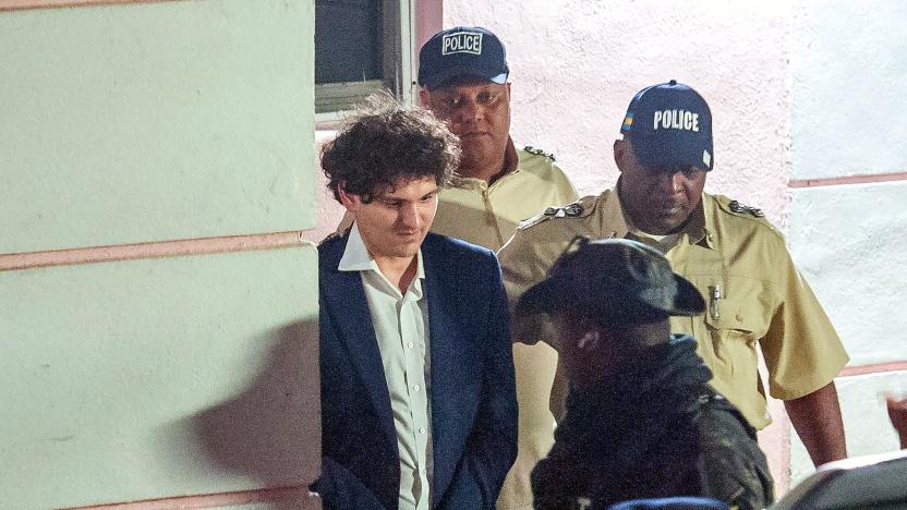 TOPSHOT - FTX founder Sam Bankman-Fried (L) is led away handcuffed by officers of the Royal Bahamas Police Force in Nassau, Bahamas on December 13, 2022. - Disgraced cryptocurrency tycoon Sam Bankman-Fried was hit with multiple criminal charges December 13, 2022, accused of committing one of the biggest financial frauds in US history. Bankman-Fried will serve time at The Bahamas Department of Corrections until February 8, 2023. (Photo by Mario Duncanson / AFP) (Photo by MARIO DUNCANSON/AFP via Getty Images)