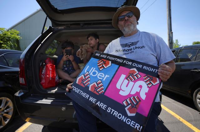 App driver Felipe Martinez and his sons Anthony and Felipe, attend a protest against Uber's elimination of fuel surcharges for drivers amid high gas prices, in Saugus, Massachusetts, U.S. June 14, 2022. REUTERS/Brian Snyder