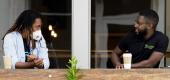 Two people chat over coffee. (C.B. Schmelter/AP)