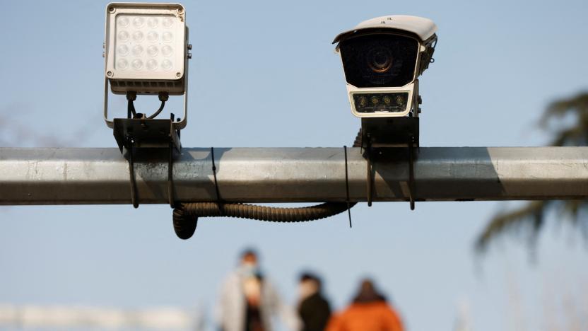 Pedestrians walk on an overpass near a surveillance camera overlooking a street in Beijing, China December 14, 2021. Picture taken December 14, 2021. REUTERS/Carlos Garcia Rawlins