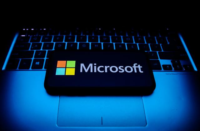 Microsoft logo displayed on a phone screen and a laptop keyboard are seen in this illustration photo taken in Krakow, Poland on October 30, 2021. (Photo by Jakub Porzycki/NurPhoto via Getty Images)