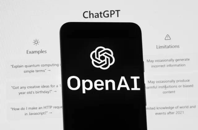 The OpenAI logo is seen on a mobile phone in front of a computer screen which displays the ChatGPT home Screen, Friday, March 17, 2023, in Boston. (AP Photo/Michael Dwyer)