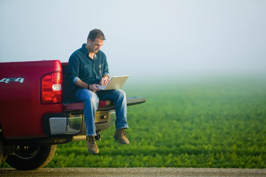 Farmer Using Laptop from Tailgate of Truck