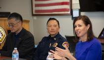 A man in black, a cop and a woman wearing a blue top sitting together.