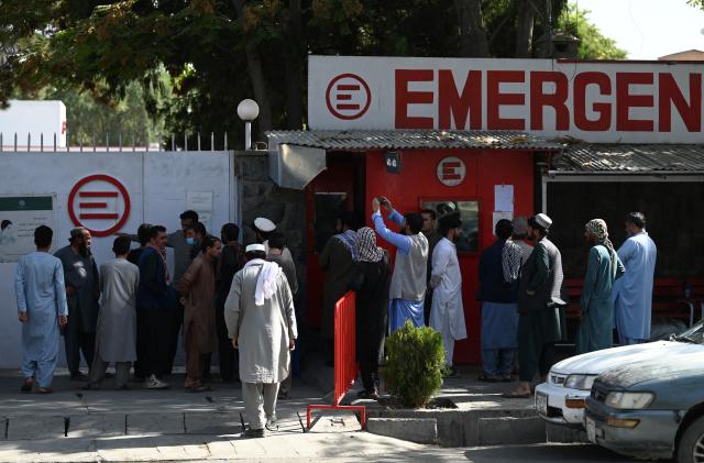 People gather to check on missing relatives a day after a twin suicide bombs attack, which killed scores of people including 13 US troops outside Kabul airport, at a hospital run by Italian NGO Emergency in Kabul on August 27, 2021. (Photo by Aamir QURESHI / AFP) (Photo by AAMIR QURESHI/AFP via Getty Images)