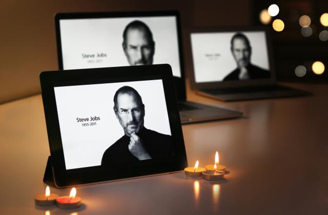 "Riyadh Saudi Arabia - September 24, 2012: An iPad displays Steve Jobs, alongside candles, offer a simple goodbye to the former CEO of Apple Inc, Steve Jobs."