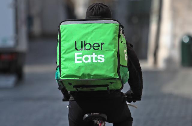 An Uber Eats bike delivery worker pedals away to their next delivery.