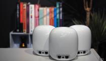 Image of three Nest WiFi Pro units, rear-on, in front of a blurred bookcase.