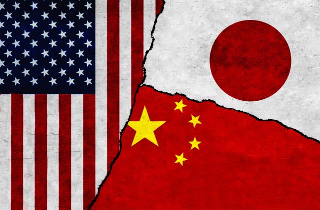 USA, Japan and China flags on wall with crack. Japan, United States of America and China conflict