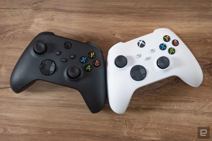 Two Xbox Wireless Controllers, one black and the other white.