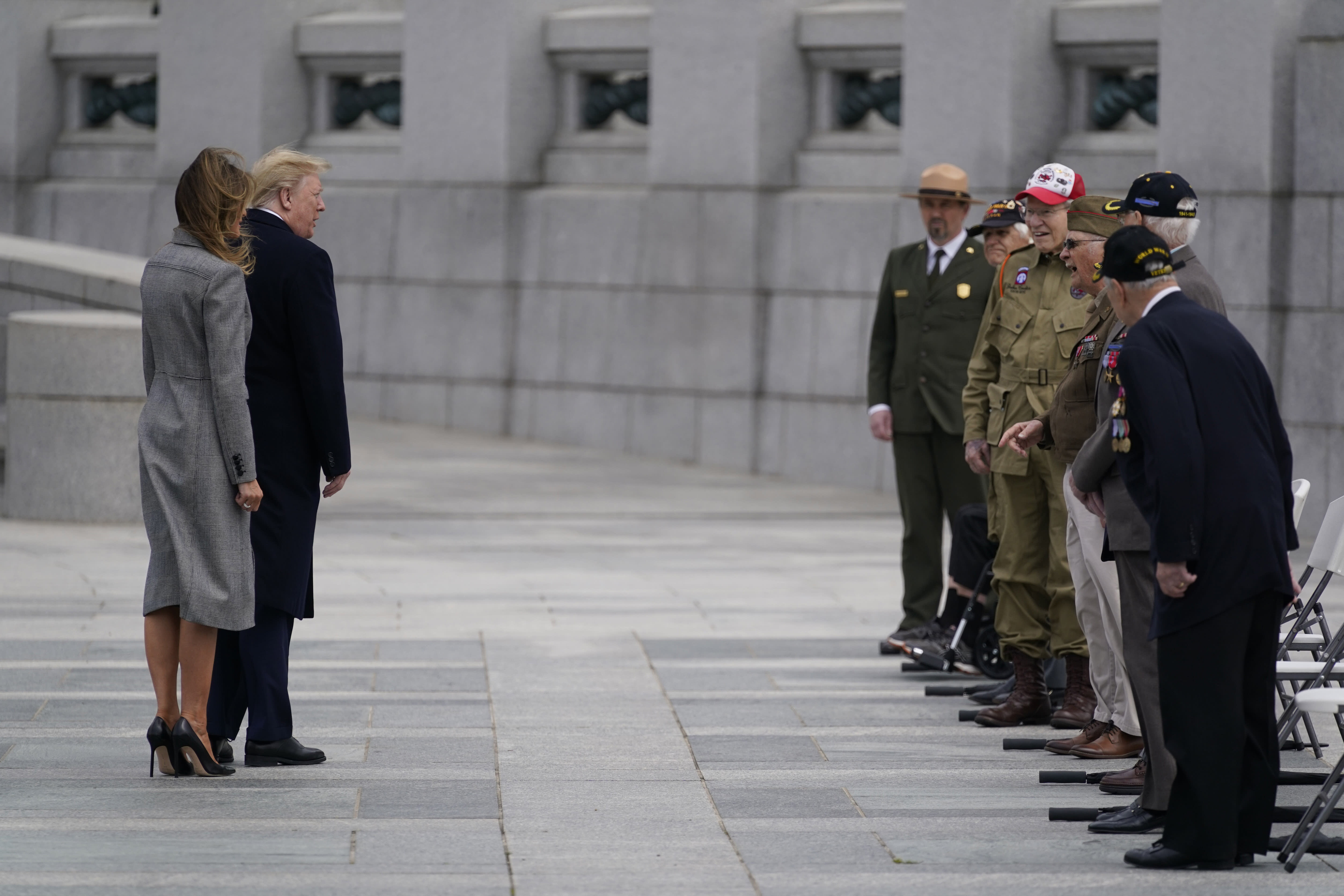 President Donald Trump and first lady Melania Trump greet veterans during a ceremony at the World War II Memorial to commemorate the 75th anniversary of Victory in Europe Day, Friday, May 8, 2020, in Washington. (AP Photo/Evan Vucci)