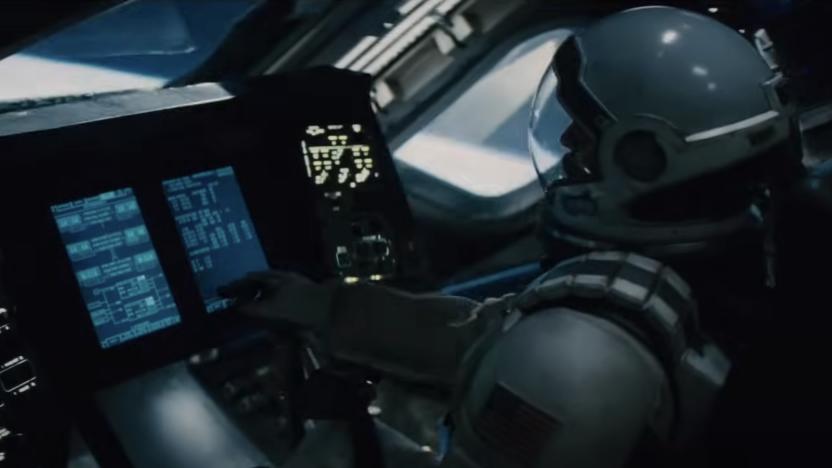 A still from the trailer for the movie Interstellar showing an astronaut sitting at a control panel in a space ship