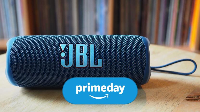 A JBL speaker sits on a wooden table. The Amazon Prime Day logo is layered on top of the image. 