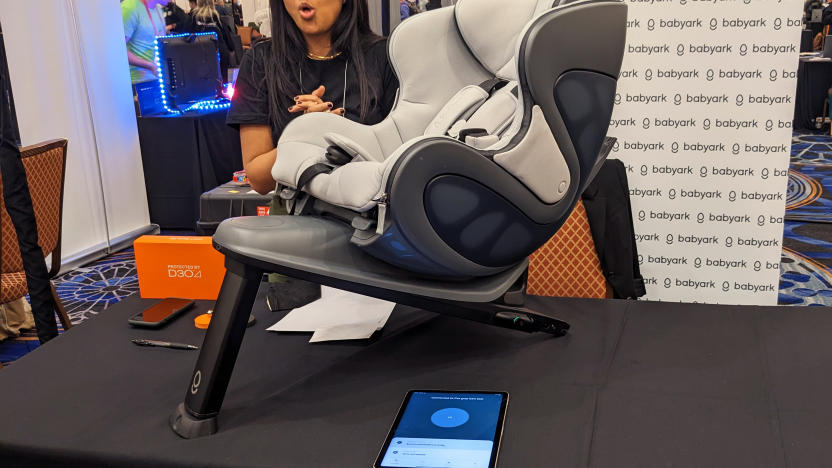 The Babyark children's car seat uses sensor-laden anticrash materials to keep your kids safe in auto wrecks. It's displayed here at a small table during CES 2023 with a Babyark representative behind it discussing the product.