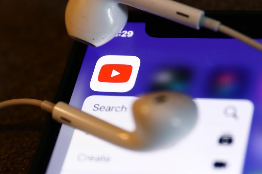 YouTube icon displayed on a phone and headphones are seen in this illustration photo taken in Krakow, Poland on August 22, 2022. (Photo by Jakub Porzycki/NurPhoto via Getty Images)