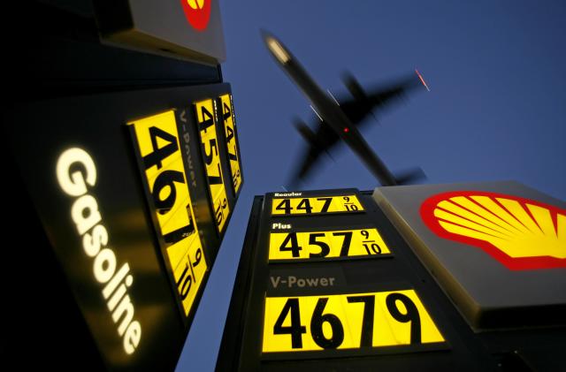 Gasoline prices are advertised at a gas station near Lindbergh Field as a plane approaches to land in San Diego, California June 1, 2008. REUTERS/Mike Blake      (UNITED STATES)