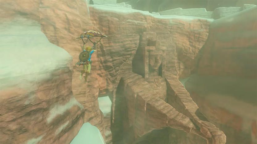 Link descends into a canyon using a paraglider in The Legend of Zelda: Breath of the Wild.