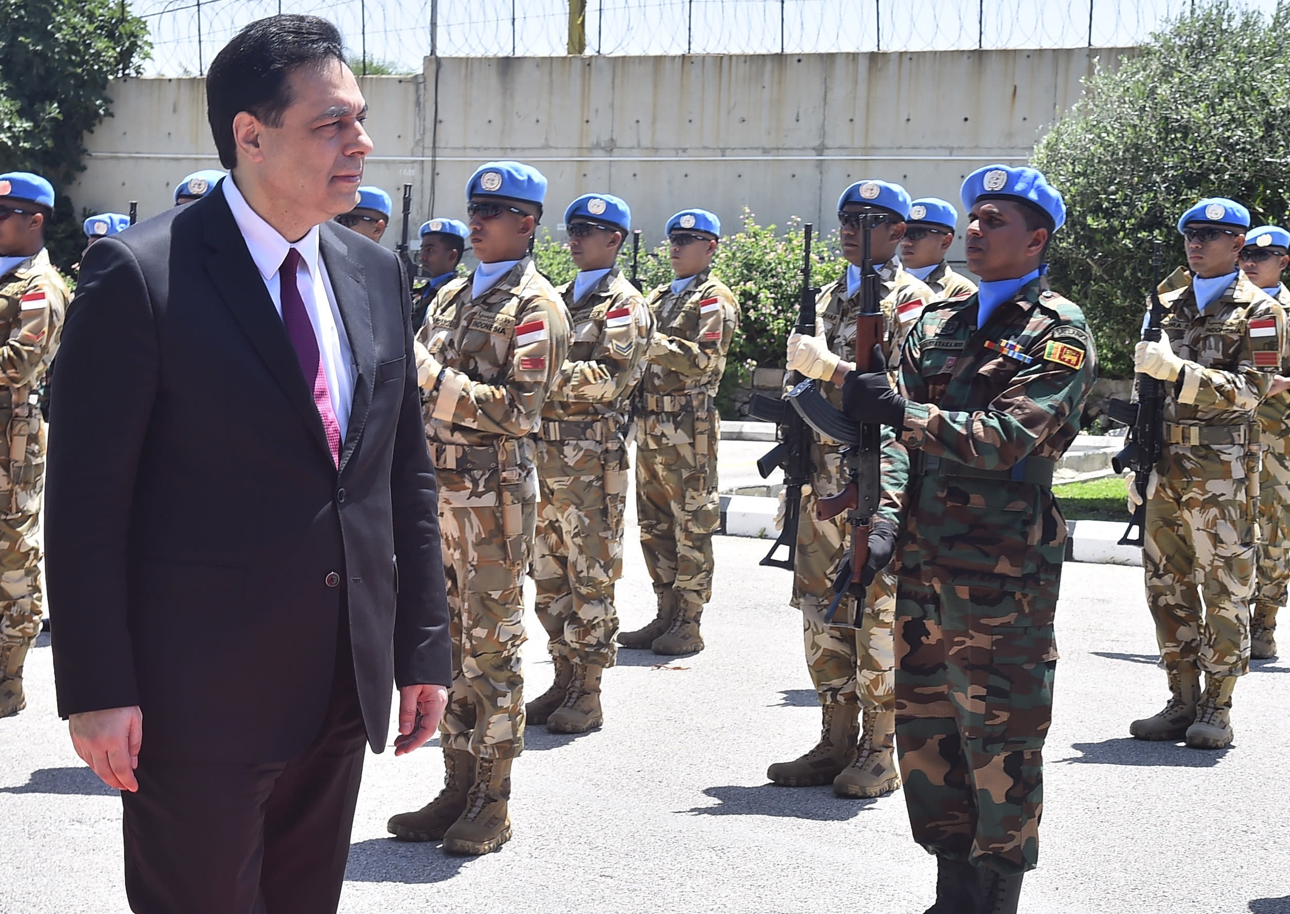 In this photo released by Lebanon's official government photographer Dalati Nohra, Lebanese Prime Minister Hassan Diab reviews the honor guard of the United Nations peacekeepers, upon his arrival at their headquarters in the southern coastal border town of Naqoura, Lebanon, Wednesday, May 27, 2020. The visit comes against the backdrop of a war of words between Israel and Lebanese officials, including the powerful Hezbollah group, over the mandate of the U.N. troops, known as UNIFIL, deployed in southern Lebanon since an Israel invasion in 1978. (Dalati Nohra via AP)