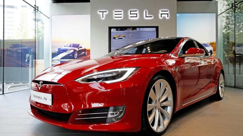 A red Tesla shown inside a Tesla showroom.