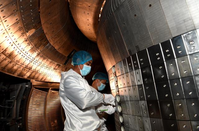 Staff members perform an upgrade to the experimental advanced superconducting tokamak EAST at the Hefei Institutes of Physical Science under the Chinese Academy of Sciences CAS on April 28, 2021. Chinese scientists have set a new world record of achieving a plasma temperature of 120 million degrees Celsius for a period of 101 seconds in the latest experiment on Friday, a key step toward the test running of a fusion reactor.     The experiment at the experimental advanced superconducting tokamak EAST, or the "Chinese artificial sun," also realized a plasma temperature of 160 million degrees Celsius, lasting for 20 seconds. (Photo by Liu Junxi/Xinhua via Getty Images)