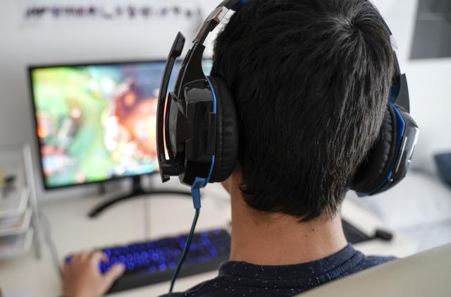 Boy with headphones playing on his computer