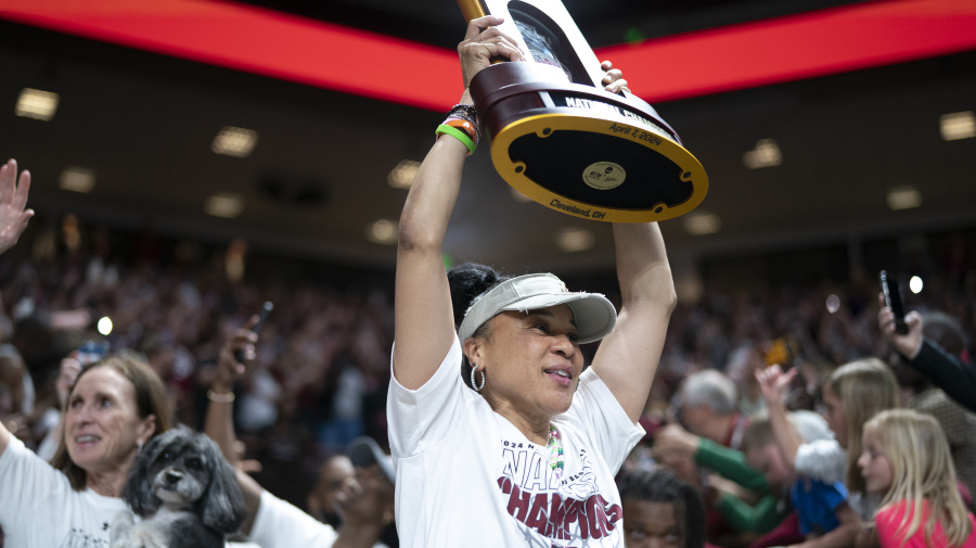 Getty Images - COLUMBIA, SOUTH CAROLINA - APRIL 8:  South Carolina coach Dawn Staley raises the NCAA Women's Basketball Championship trophy during a celebration at the Colonial Life Arena on April 8, 2024 in Columbia, South Carolina. University classes that were scheduled during the event were canceled. The South Carolina Gamecocks defeated the Iowa Hawkeyes 87-75 to cap a perfect season. 
 (Photo by Sean Rayford/Getty Images)