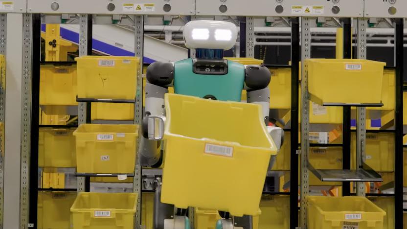 A humanoid robot with glowing eyes standing in a warehouse holding an empty yellow crate.