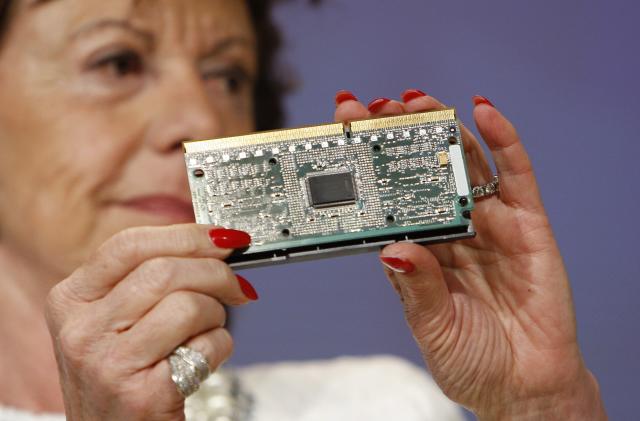 European Commissioner for Competition Neelie Kroes shows a computer chip at a news conference on Intel at the European Commission headquarters in Brussels May 13, 2009. The European Commission imposed a record 1.06 billion euros ($1.45 billion) fine on chipmaker Intel Corp on Wednesday and ordered it halt illegal rebates and other practices to squeeze out rival AMD.   REUTERS/Thierry Roge  (BELGIUM BUSINESS POLITICS SCI TECH)